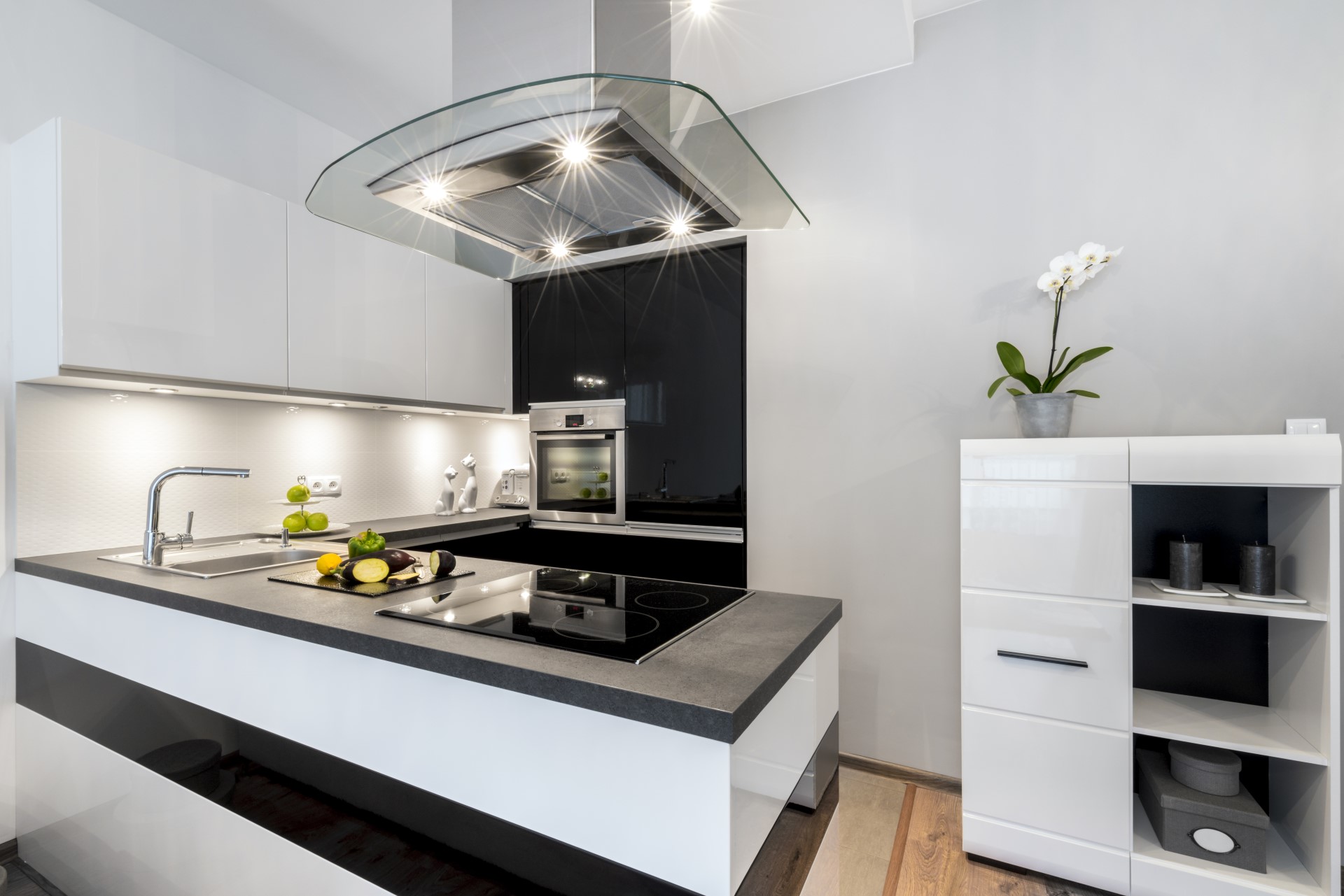 If you're looking for that edgy and cool kitchen layout, this modern design nails it. It comes with a useful functionality of using darker colors for the heavy traffic areas followed by lighter colors which help brighten everything. The glass style range hood is pretty cool too.