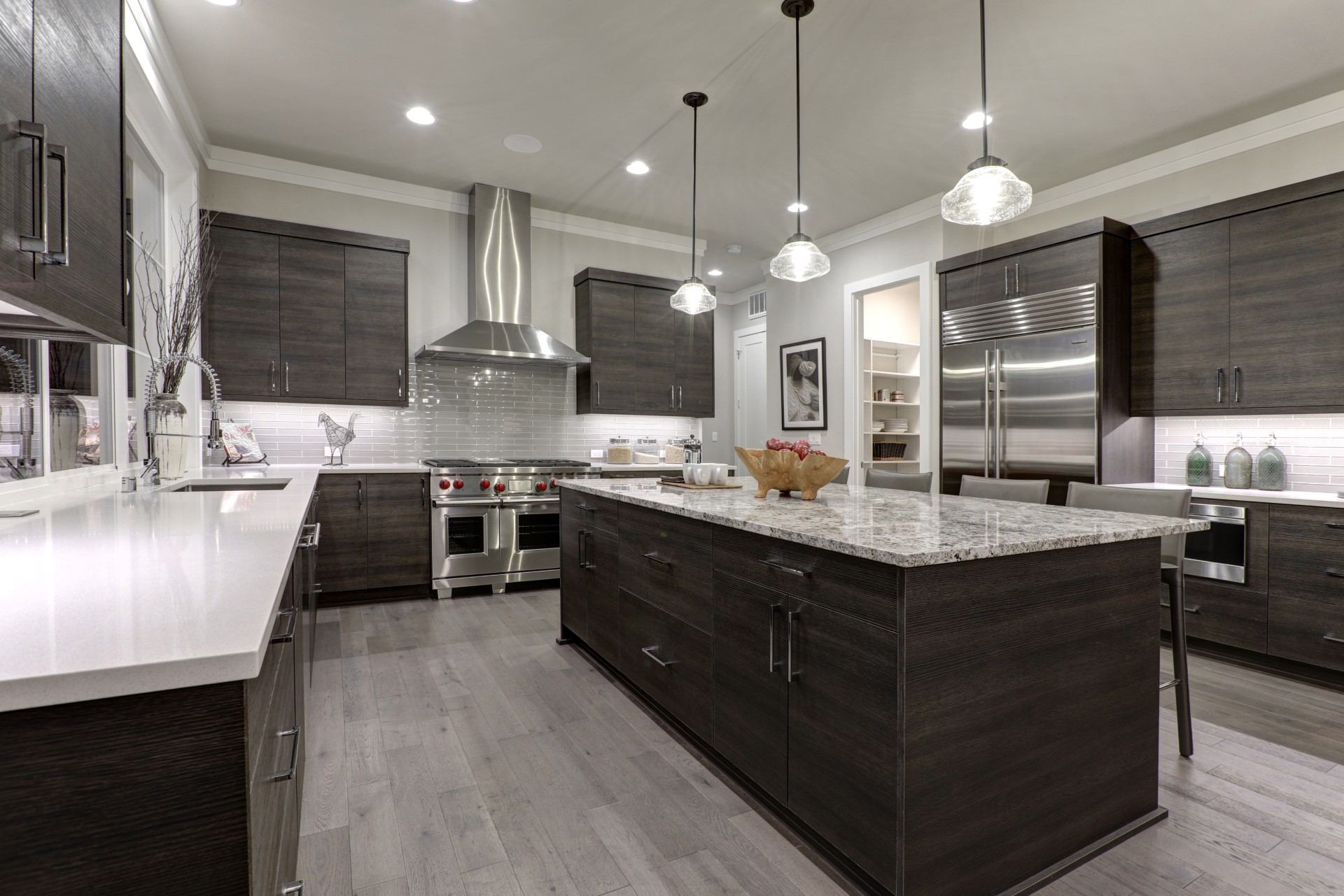 I kitchen with dark cabinets helps bring forth the beauty of your light flooring. A kitchen needs contrast and physique to achieve harmony in this modern style. When you mix wood, stone, and the bright sheen of stainless steel, it helps achieve the diversity that makes this style pop!