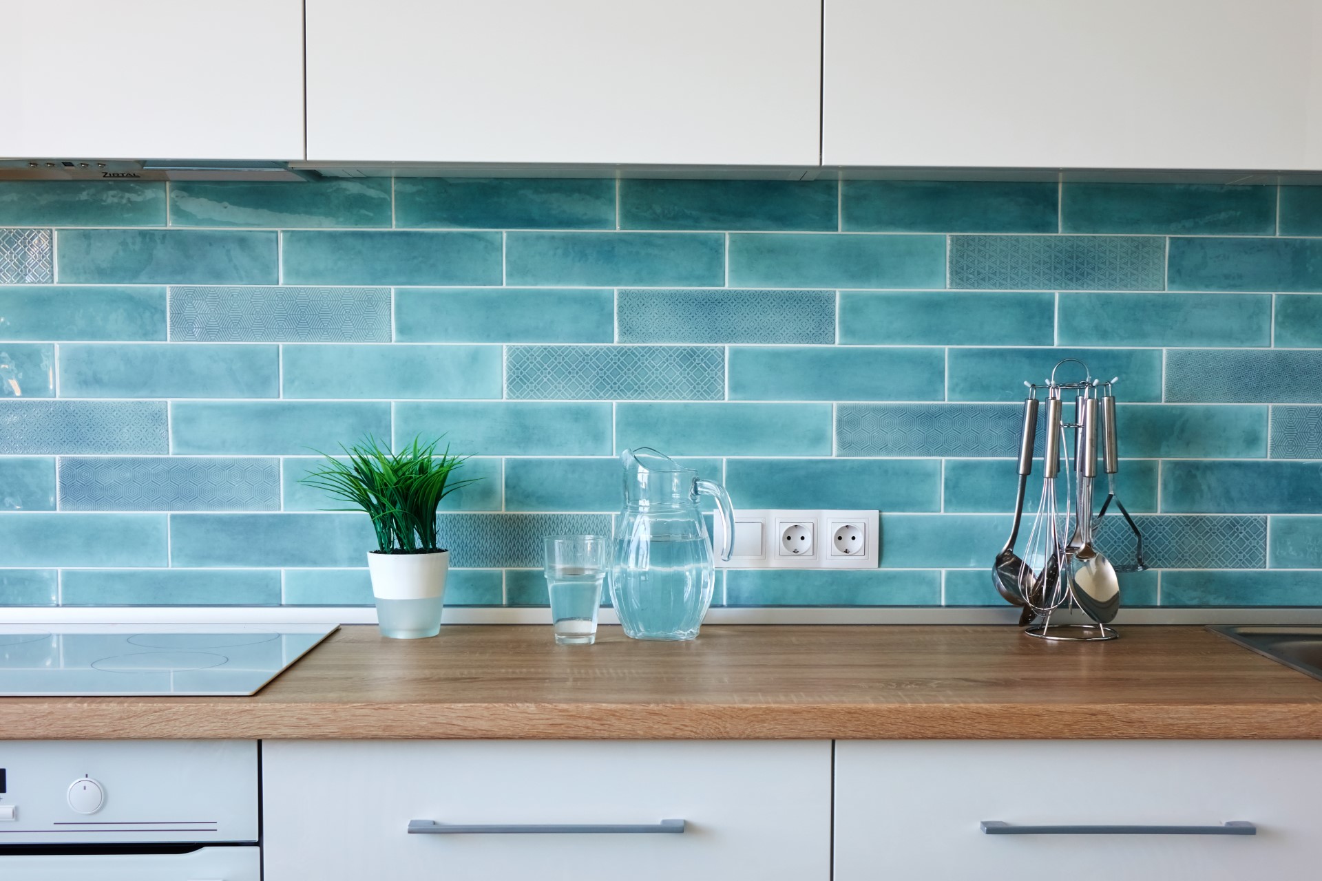 A blue backsplash coupled with a natural wood slab for a countertop is a different design that helps distinguish your kitchen from others.